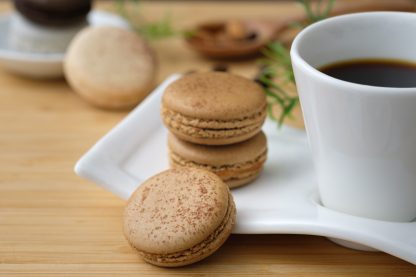 macarons next to a cup of coffee